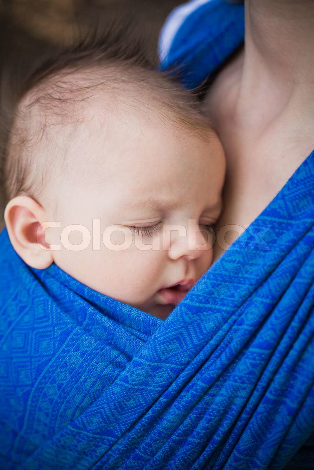 sleeping newborn baby in the sling Stock image Colourbox