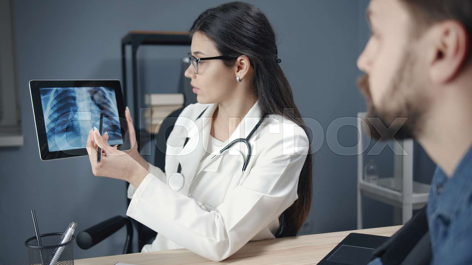 Doc explaining patient xray results Stock image Colourbox