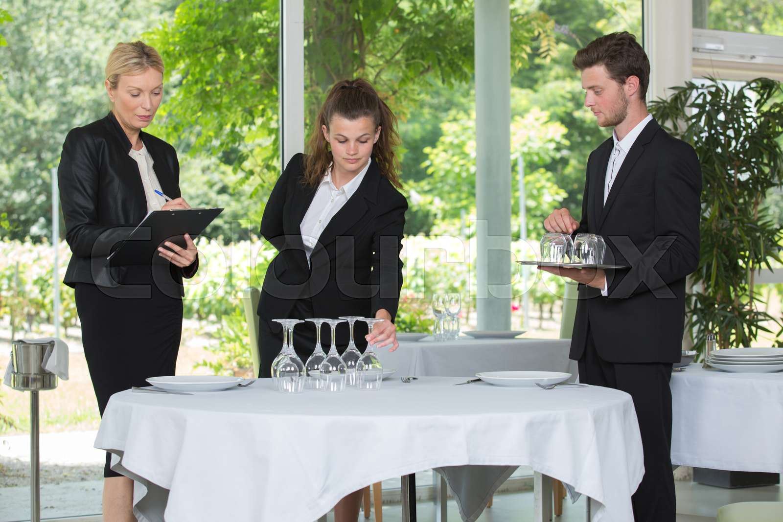 waiter setting a table in a bar | Stock image | Colourbox