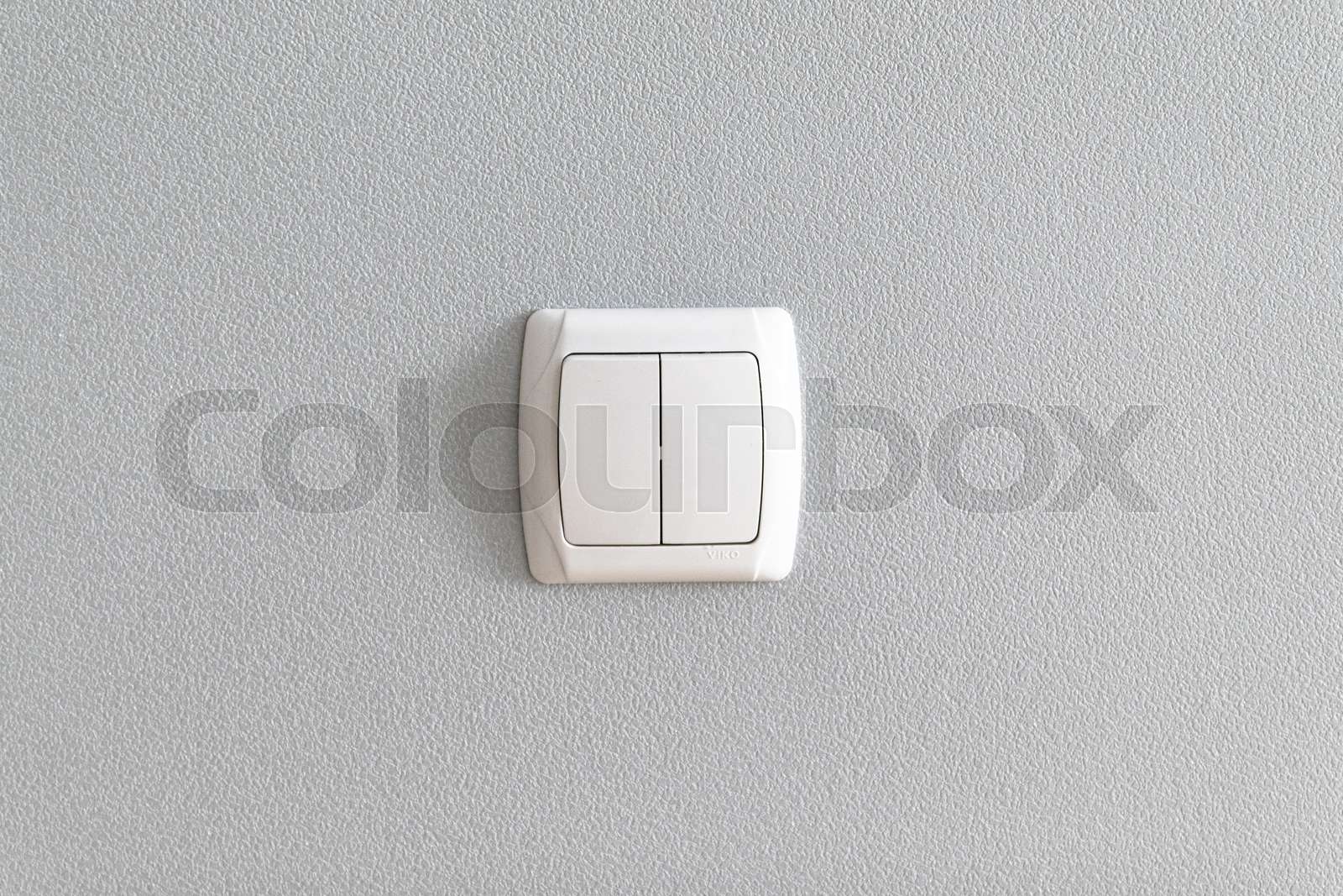 Simple light switch on grey wall. Stock image Colourbox