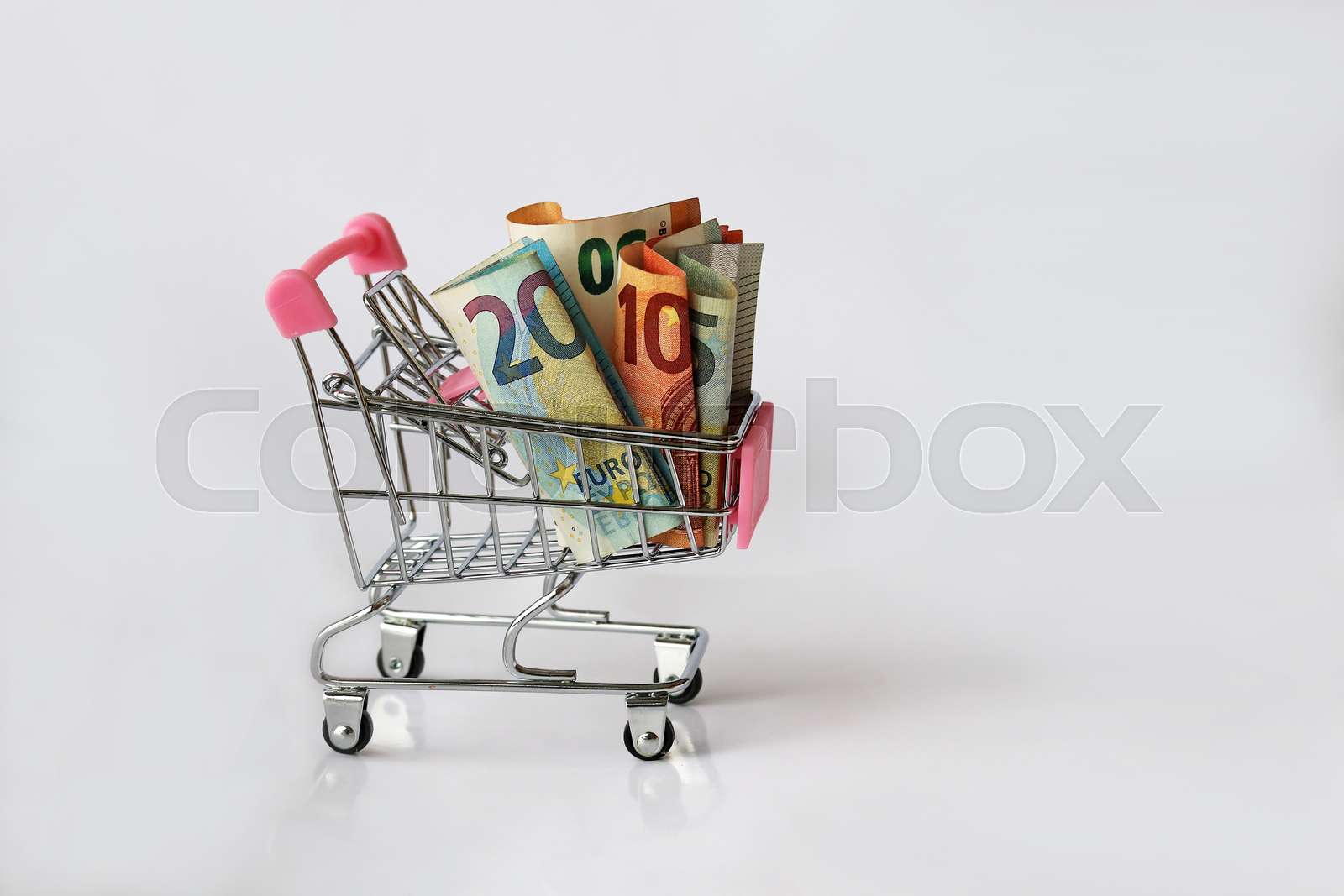 Billigend In Kauf Nehmen Einkaufen kostet Geld. Euroscheine in einem Einkaufswagen | Stock Bild