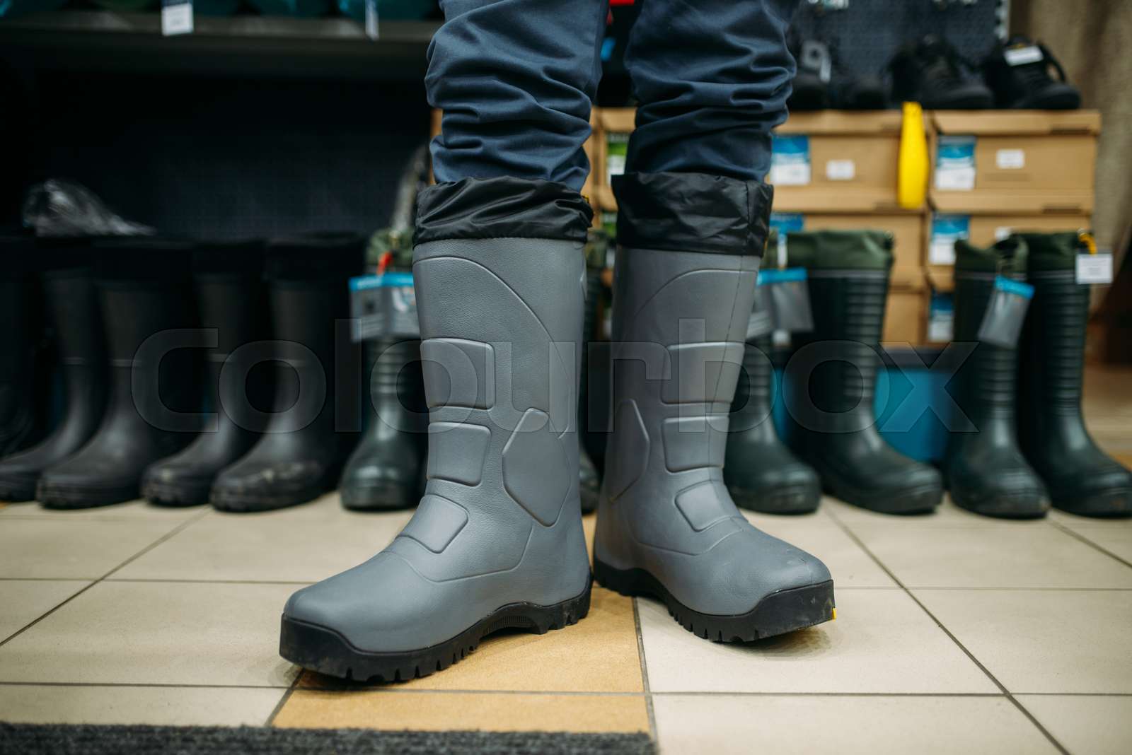 Fisherman tries on rubber boots in fishing shop Stock image Colourbox