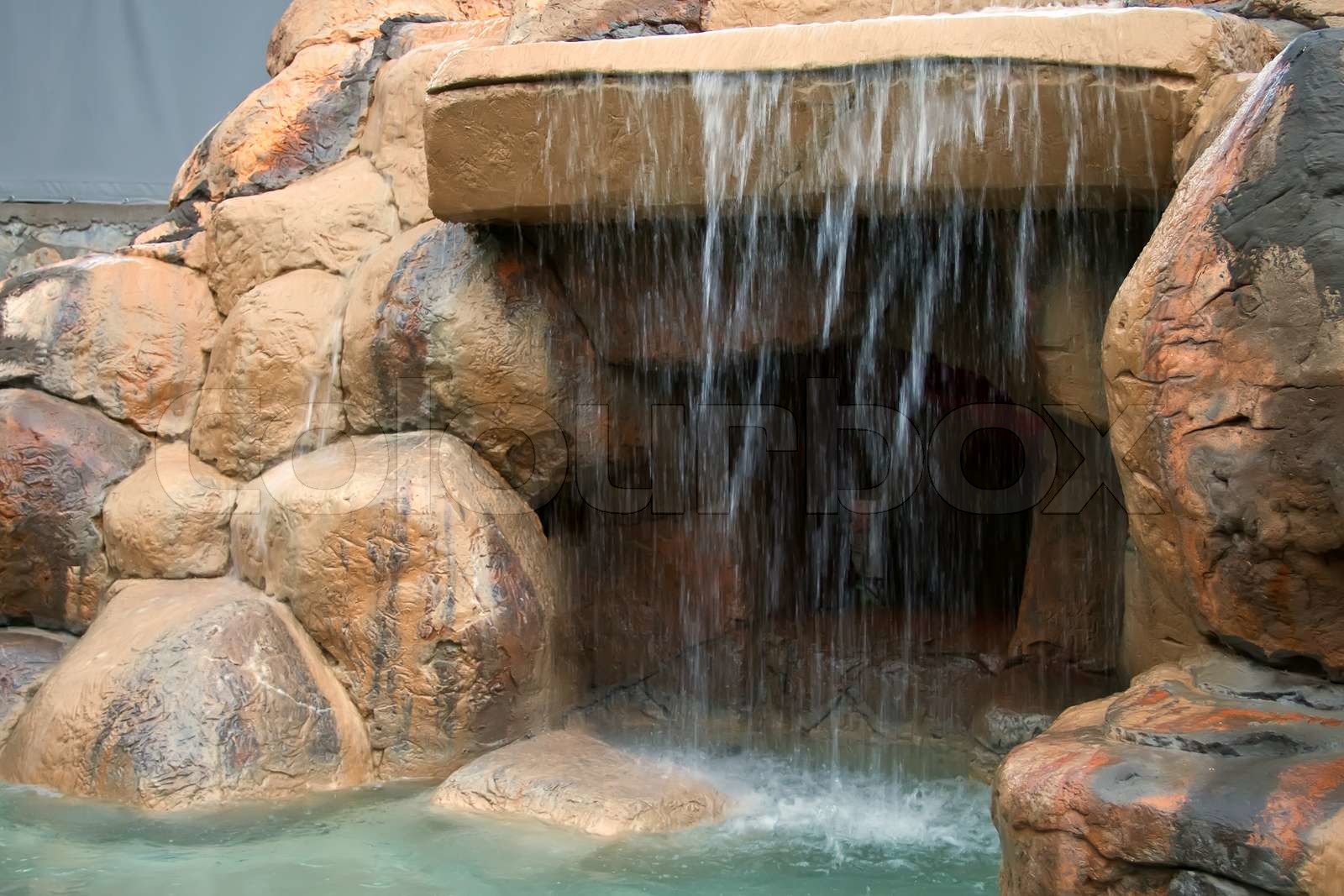 An artificial grotto with a waterfall. Stock image Colourbox
