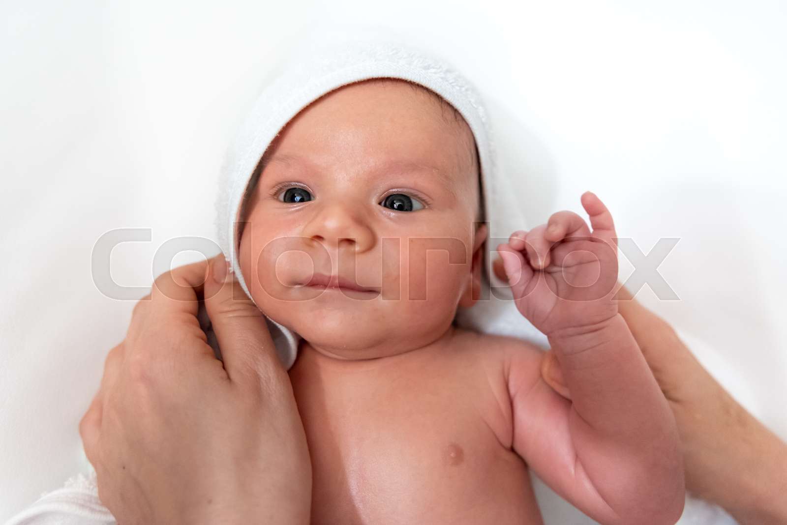 Adorable 2 months old little baby boy on towel after bath in his mother