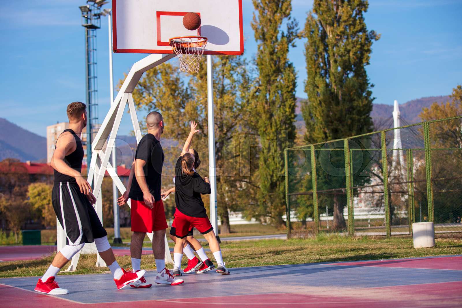 Group Of Young Friends Playing Basketball Match Stock image Colourbox