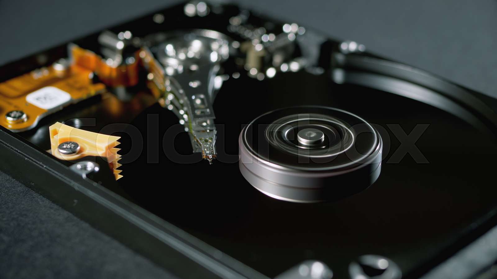 Opened Hard Disk Drive with Spinning Platter. Move of Writing