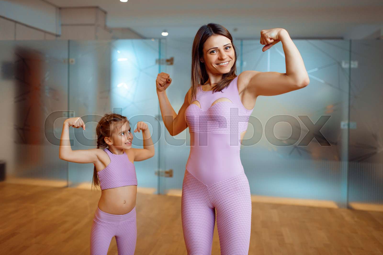 Mother and daughter shows the muscles in gym stock image colourbox