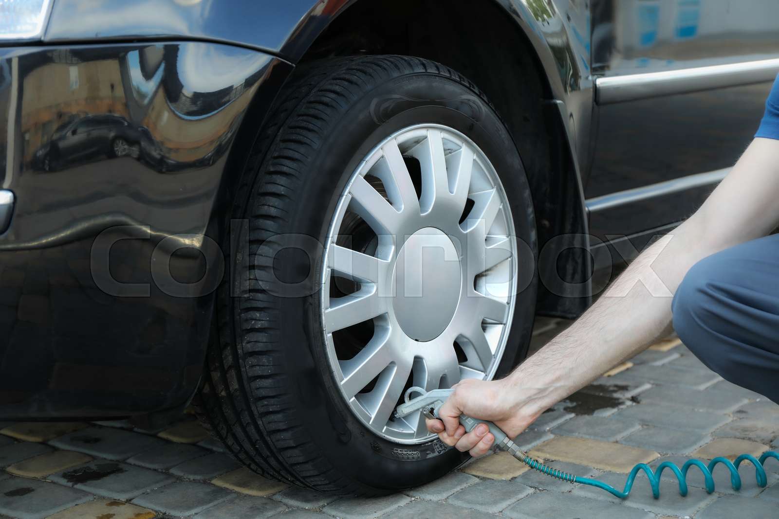 Man pumps up tires. Car inspection. Maintenance Stock image Colourbox