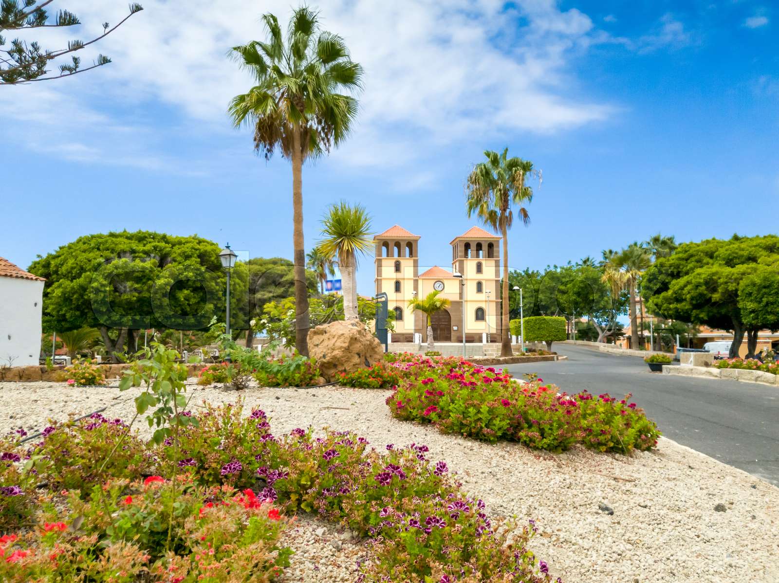 Beautiful image of flower bed in front of old church in spanish