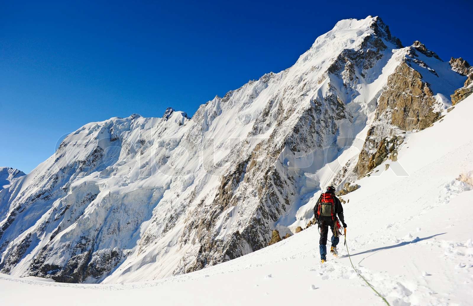 Hiker reaching summit of mountain
