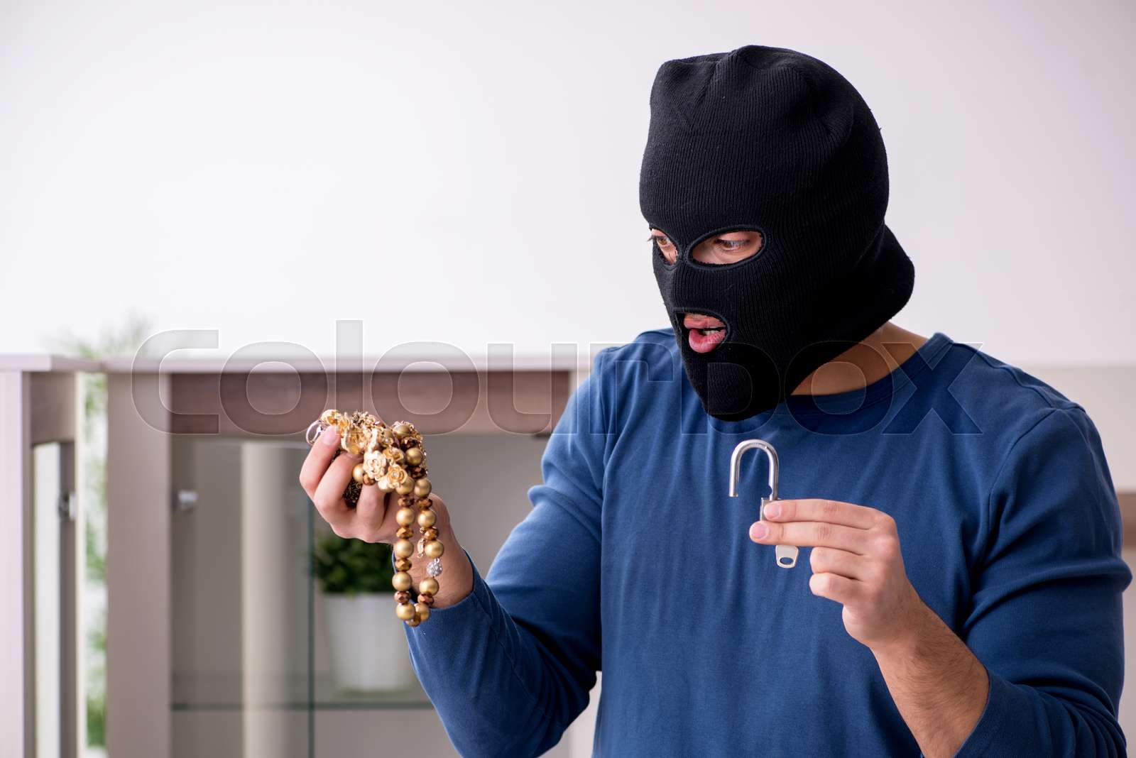 Male robber stealing valuable things from the house | Stock image ...
