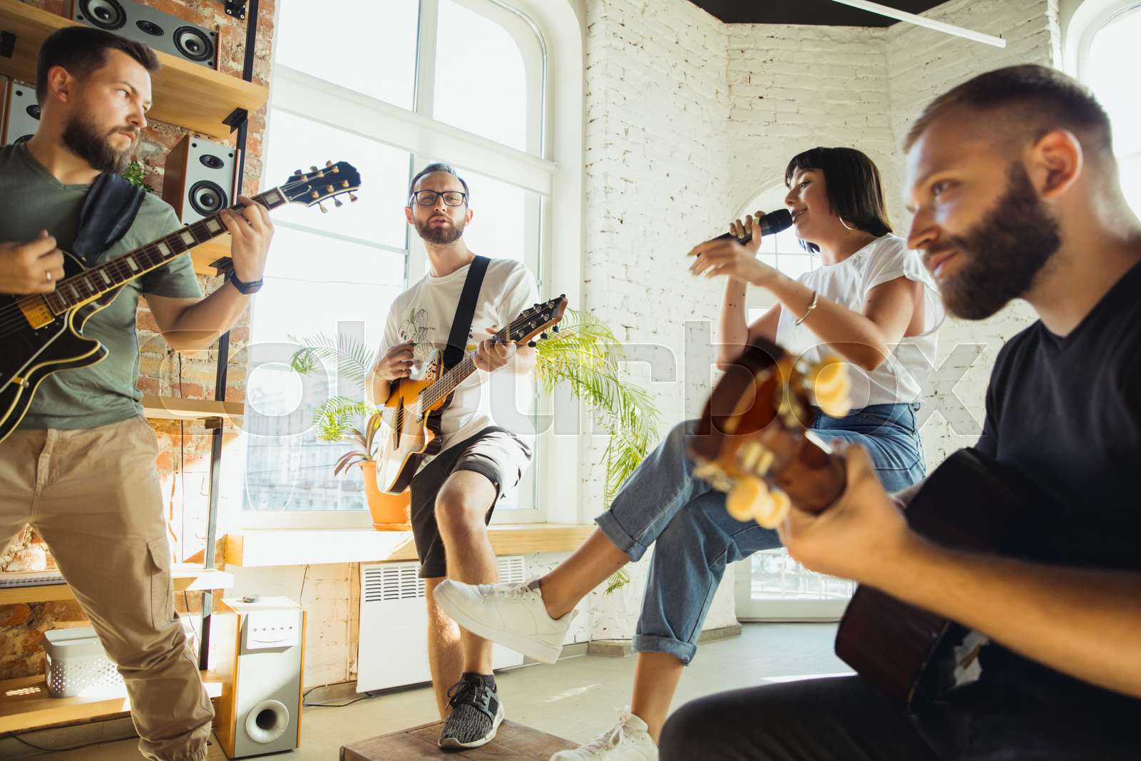Musician band jamming together in art workplace with instruments ...