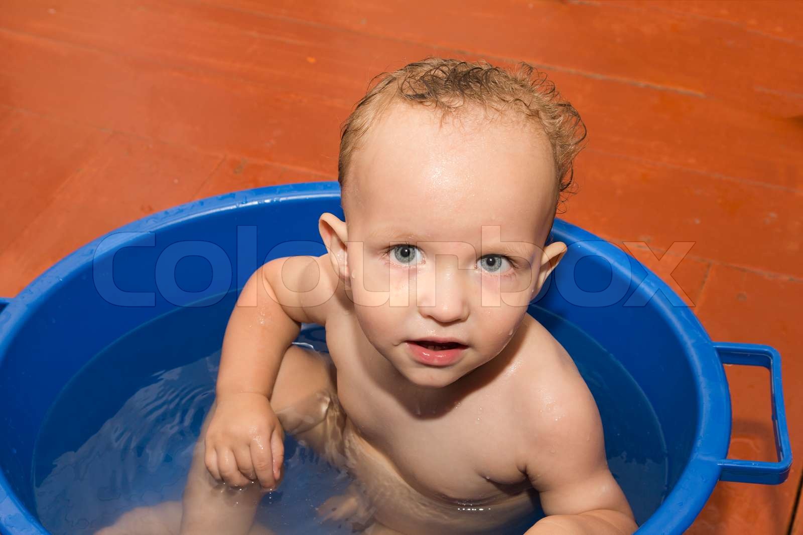 The little boy is bathed in a blue tub | Stock image | Colourbox