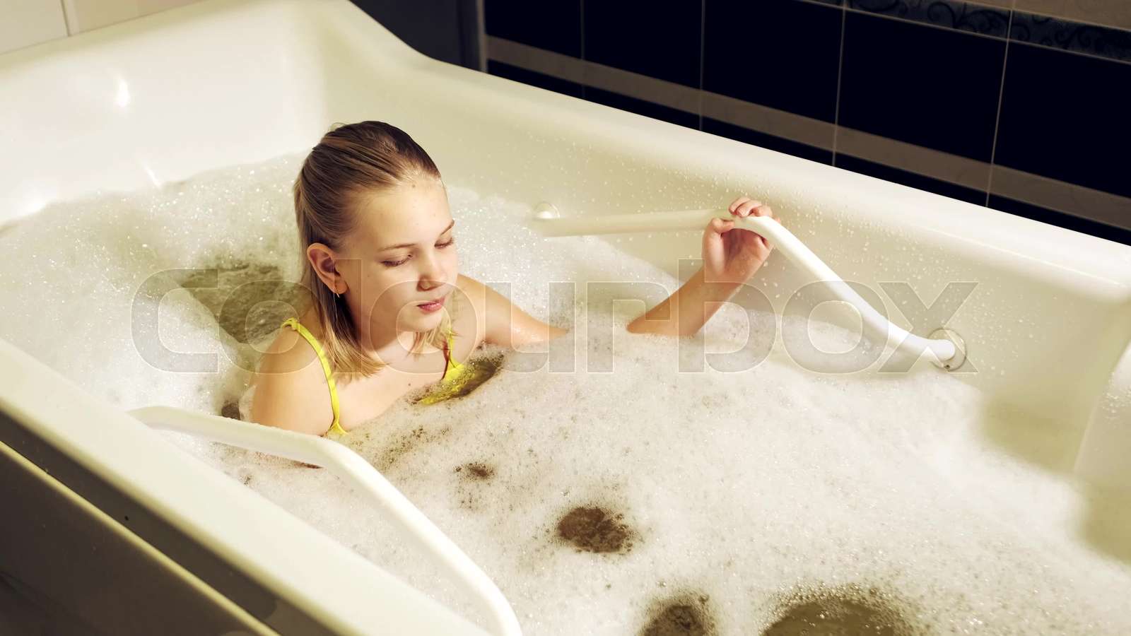 a little girl takes the procedure in a mineral bath. The patient