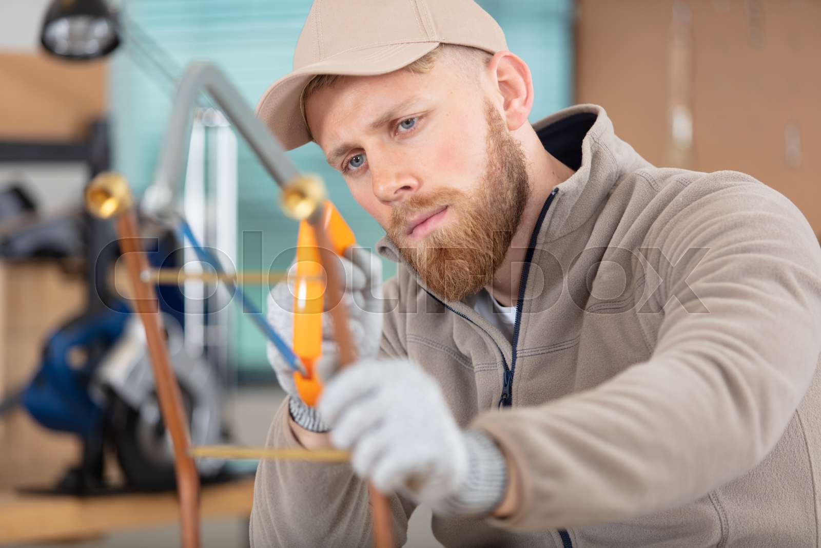 tradesman cutting copper pipe with hacksaw Stock image Colourbox