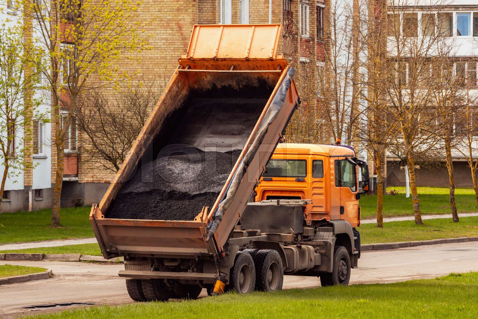 Tipper unloading fresh asphalt from body | Stock image | Colourbox
