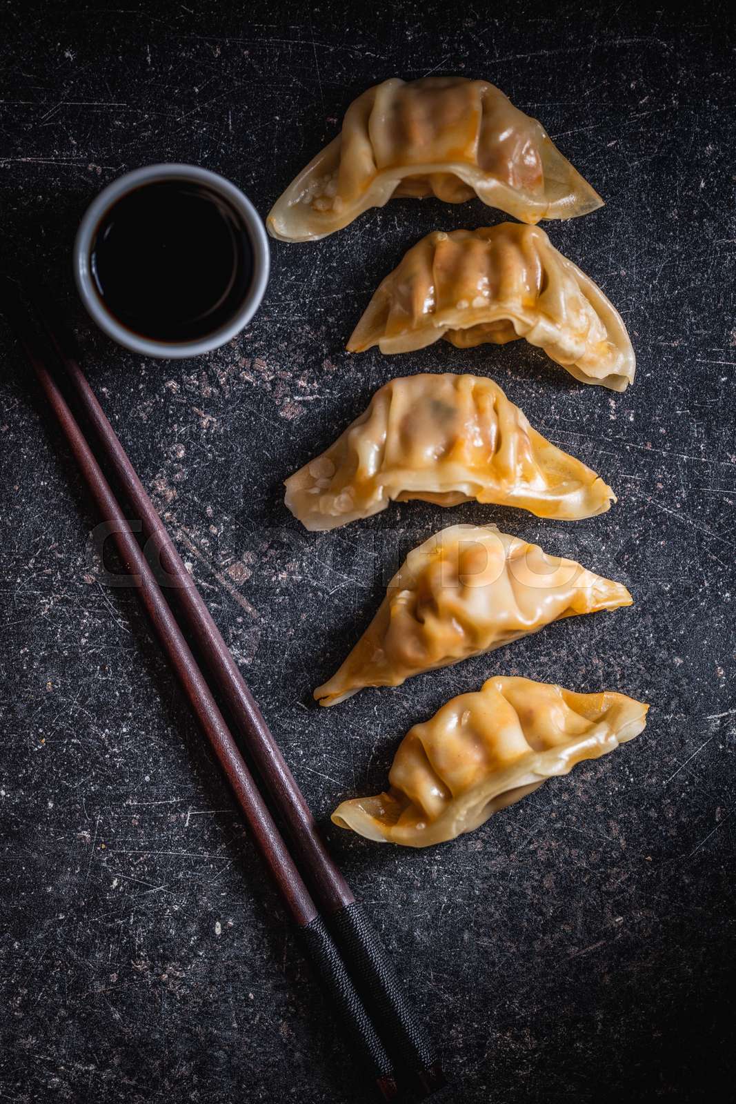 Chinese dumplings with soy sauce on black table. Stock image Colourbox