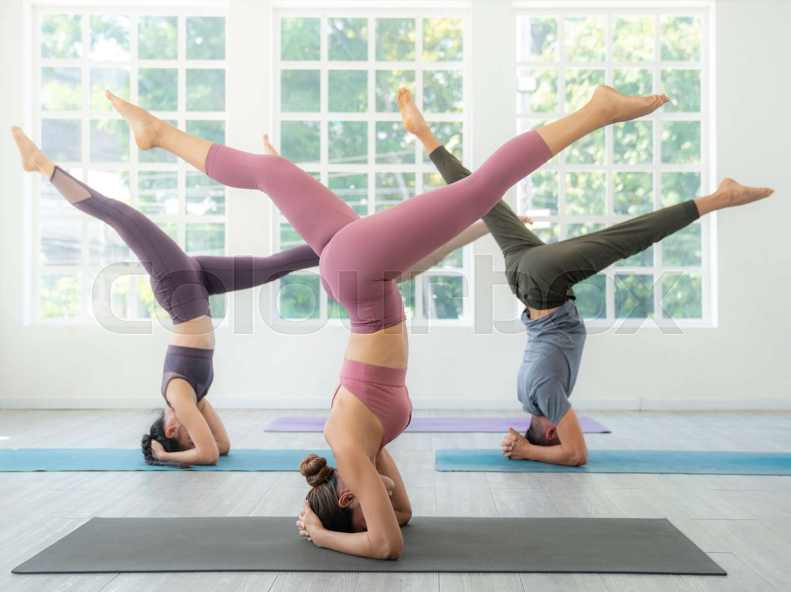 Asian yoga trainer and her student pose yoga basic position in her