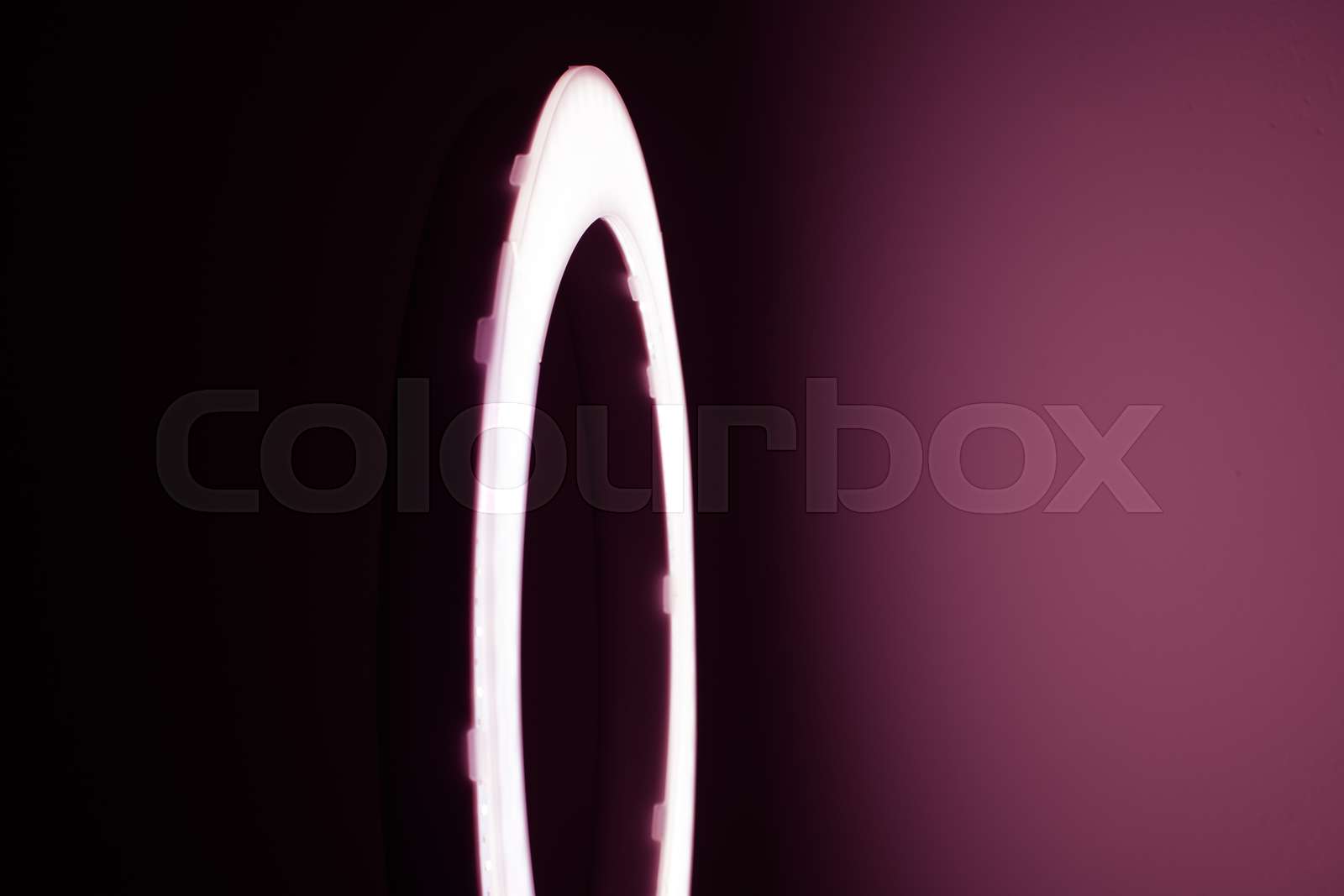 Large LED ring light in a studio room against empty walls side view ...
