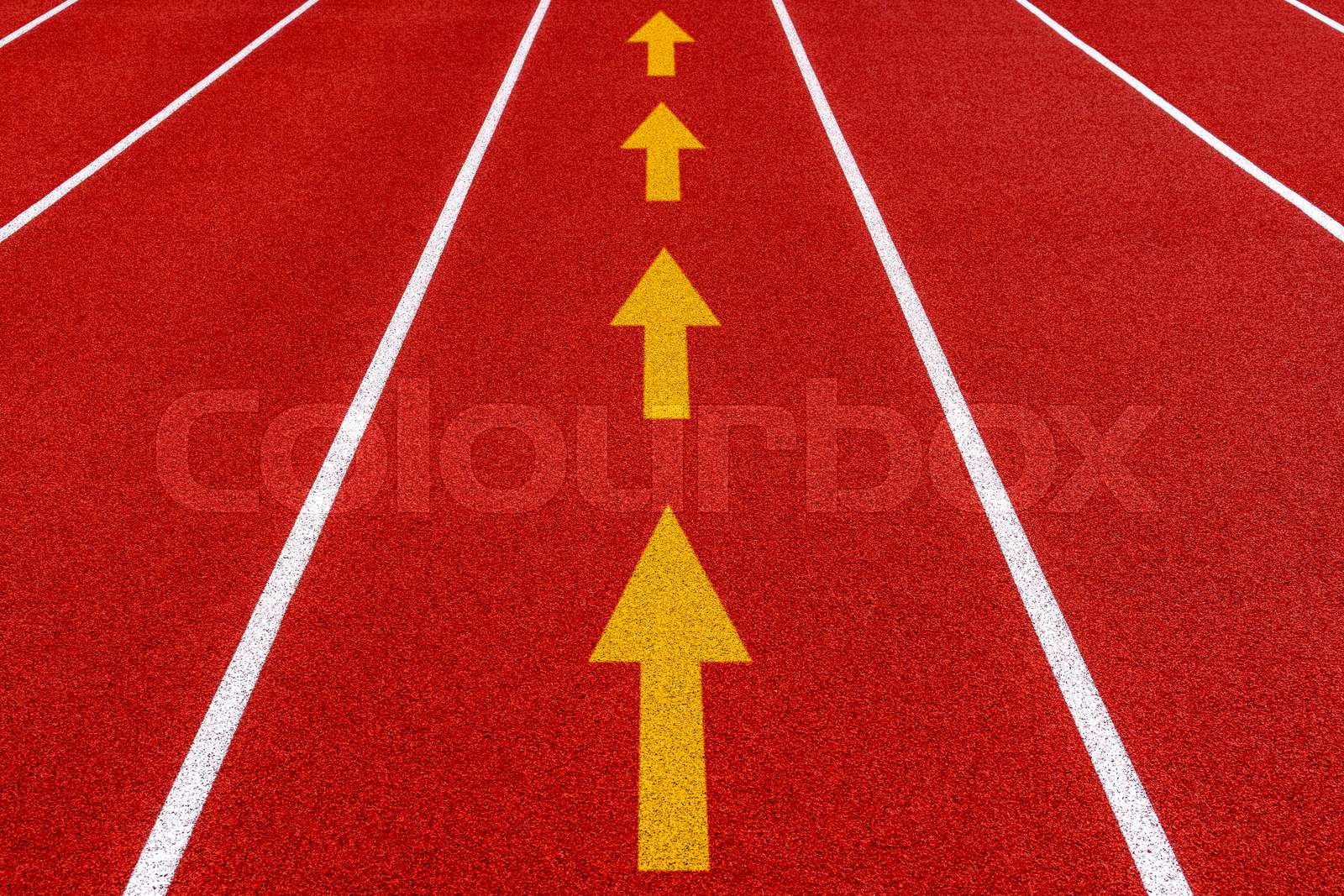 Outdoors stadium running red tartan track with white straight arrow symbols