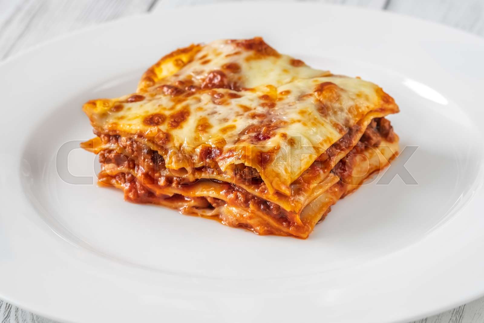 Portion of lasagne on white plate | Stock image | Colourbox