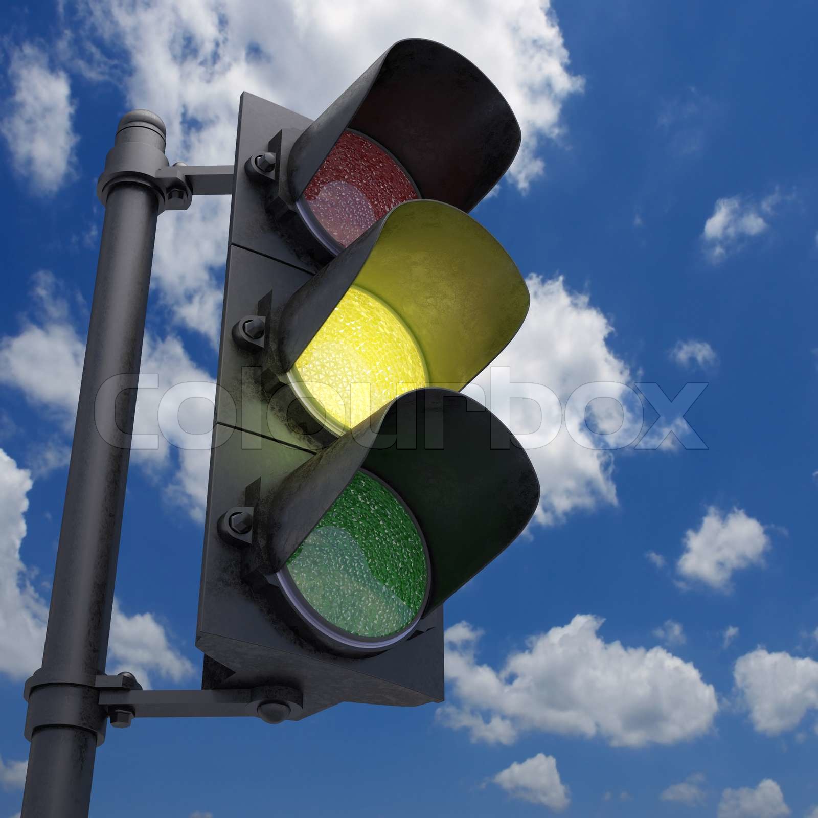 Traffic Light in a blue sky with only the yellow light on Stock image