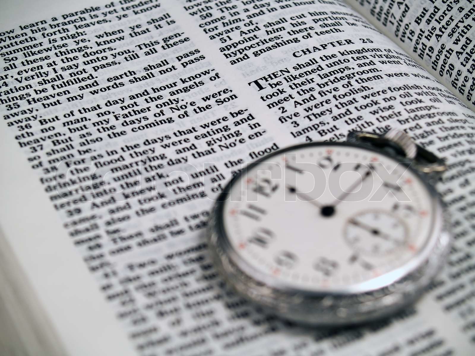The bible opened to matthew 24 36 with a pocketwatch stock image