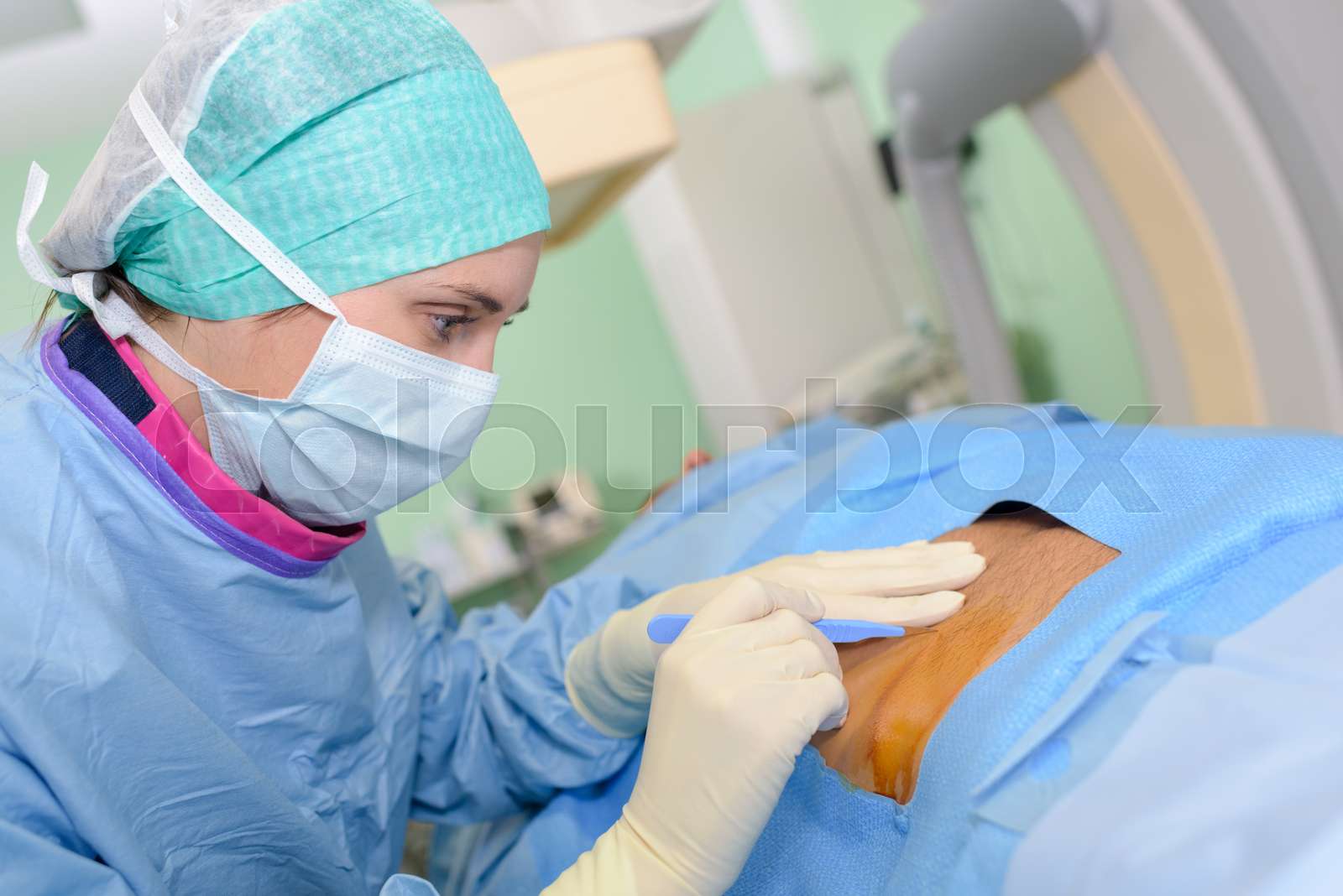 surgeon-poised-to-make-incision-in-patient-stock-image-colourbox