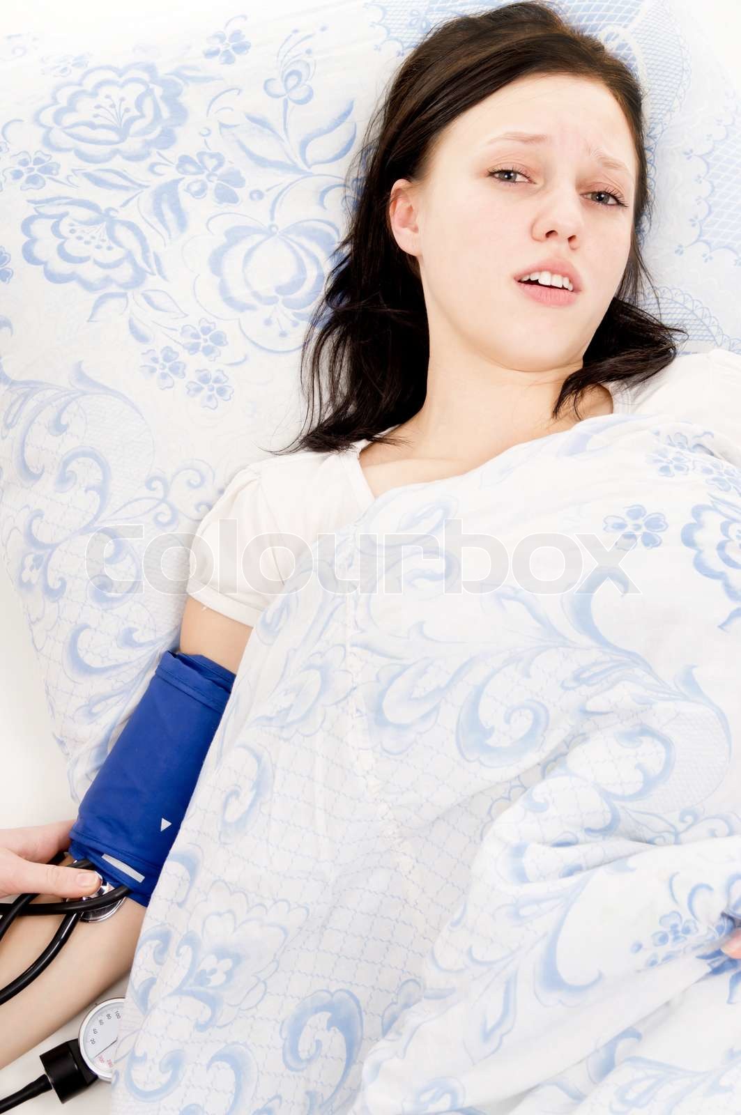 girl bad, lying on the bed and measure the pressure Stock image