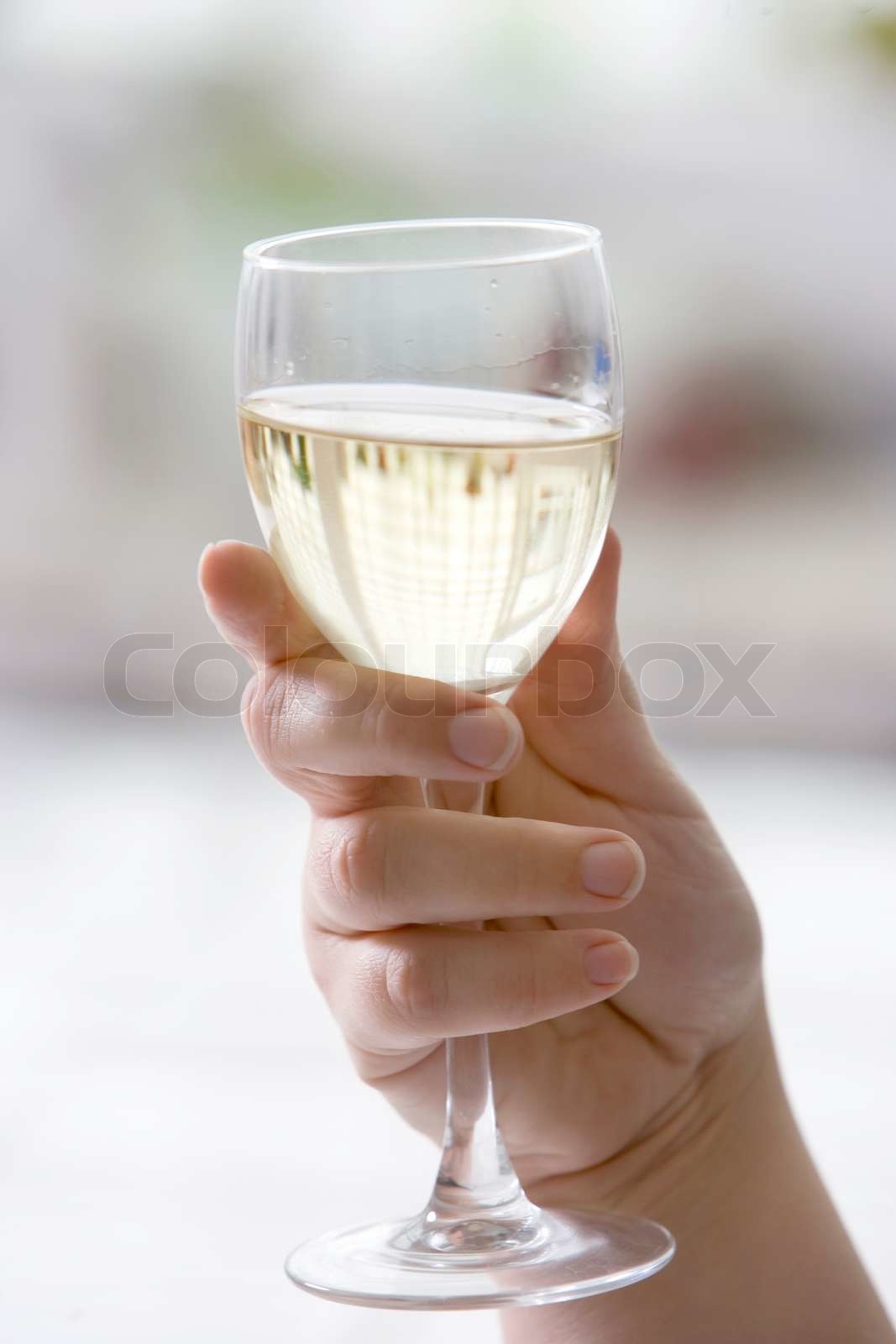 Hånd som holder et glas med hvidvin Stock foto Colourbox