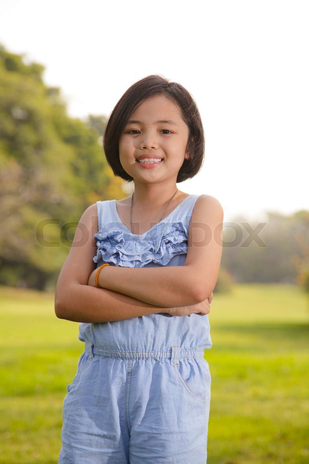 Asian little girl smiling happily in the park | Stock image | Colourbox