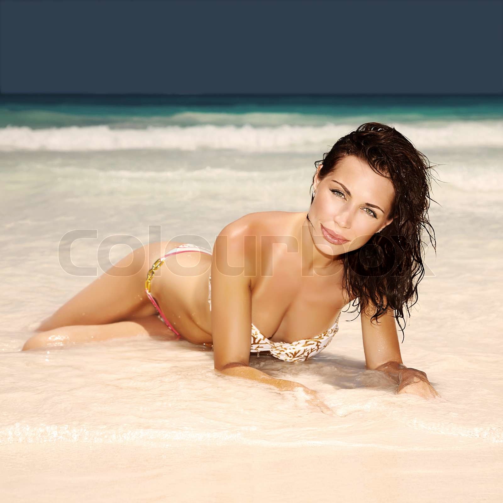 Sexy woman lying down on the beach | Stock image | Colourbox