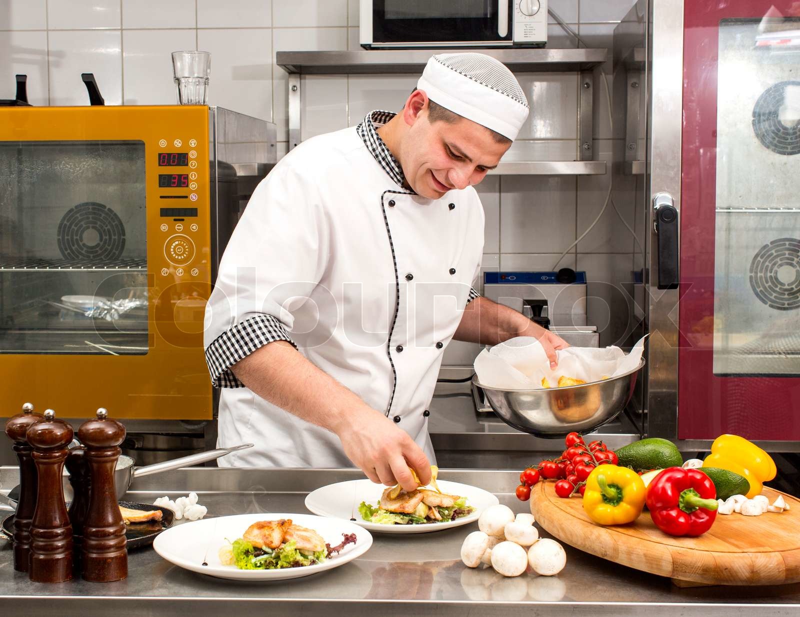 chef preparing food in the kitchen at the restaurant | Stock image
