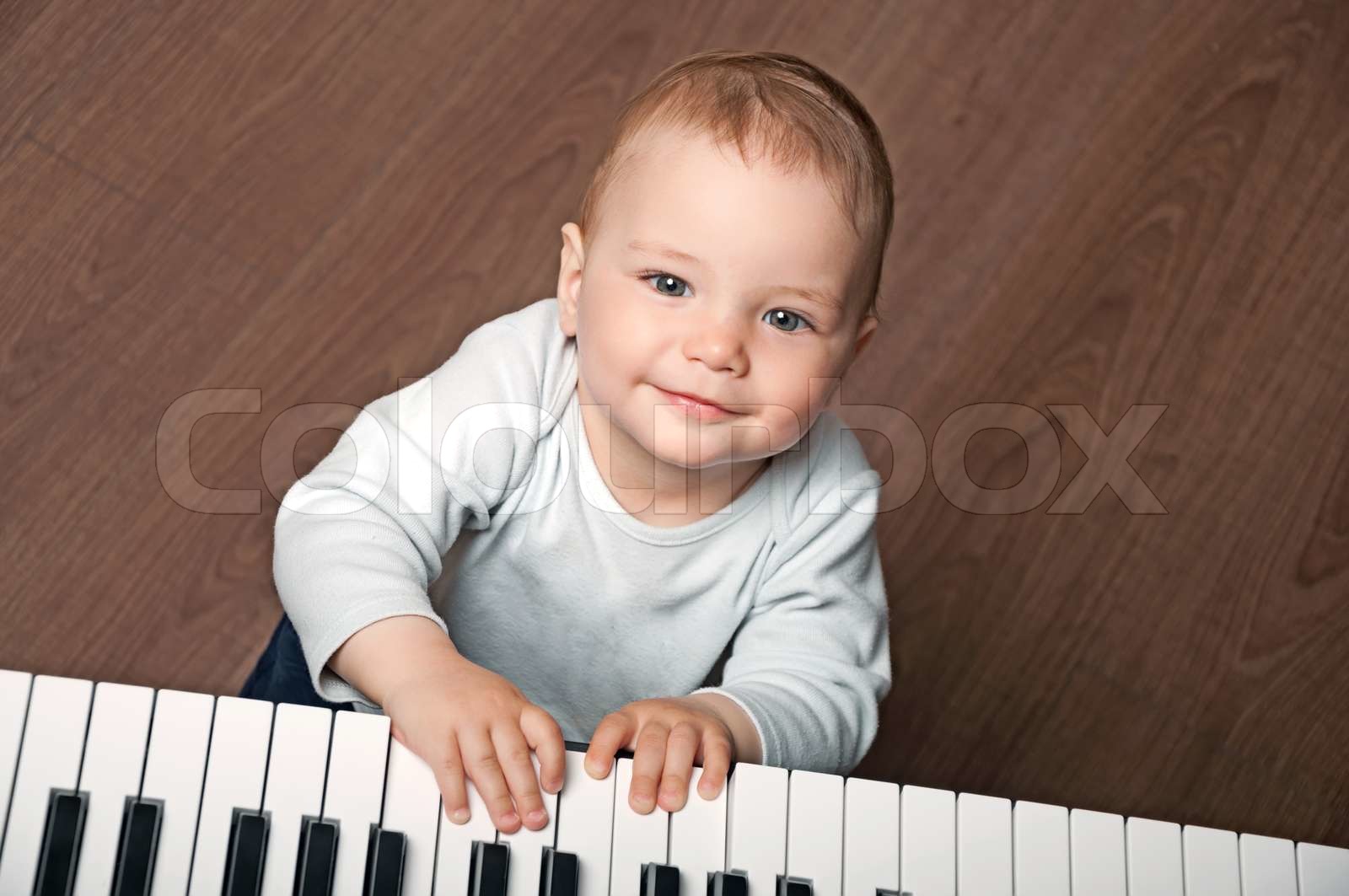 Baby spielen black and white piano | Stock Bild | Colourbox