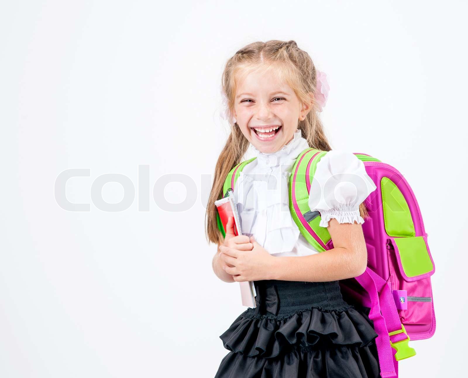niedliche kleine Mädchen in Schuluniform, mit Rucksack-Studio isoliert | Stock Bild | Colourbox