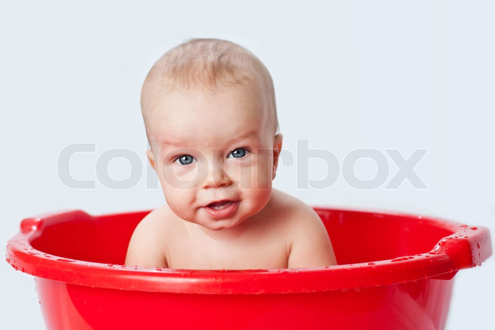 Cute Little Babe Is Bathed In A Basin Stock Image Colourbox