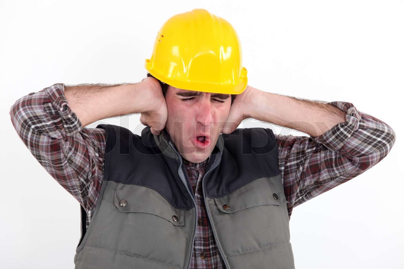 A construction worker covering his ears Stock image Colourbox