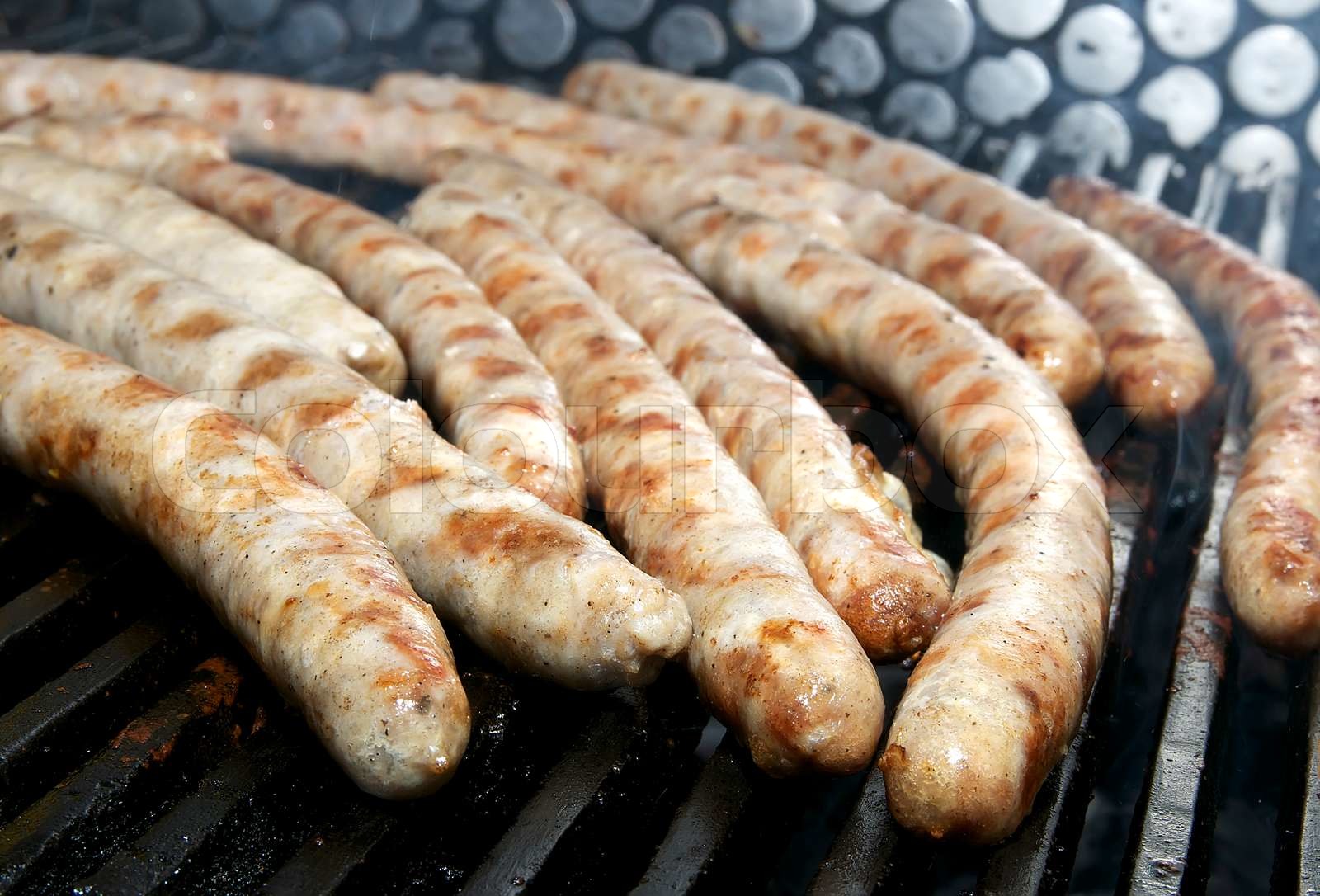 cooking sausages on the grill in the restaurant Stock image Colourbox