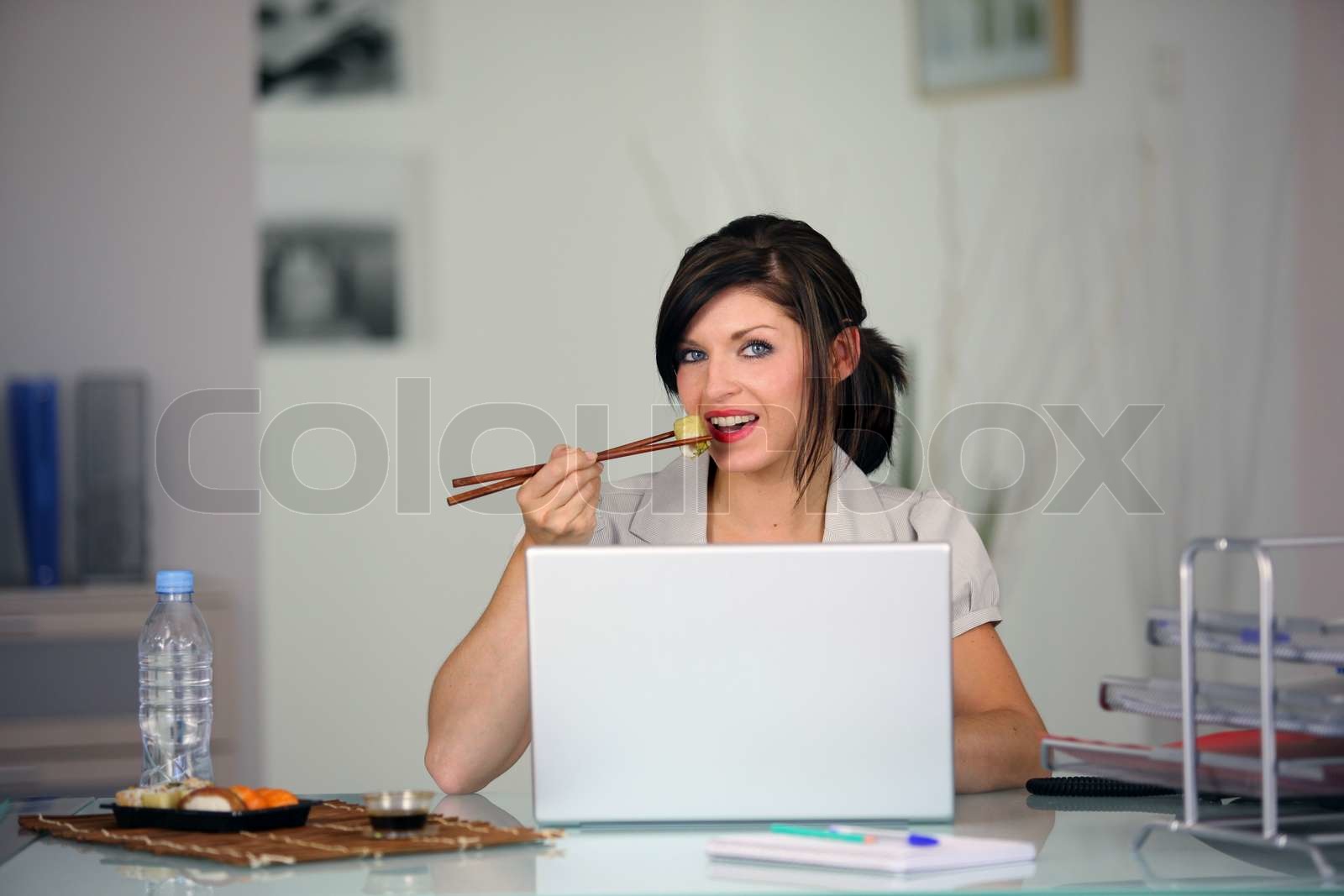 Woman eating in front of computer | Stock image | Colourbox