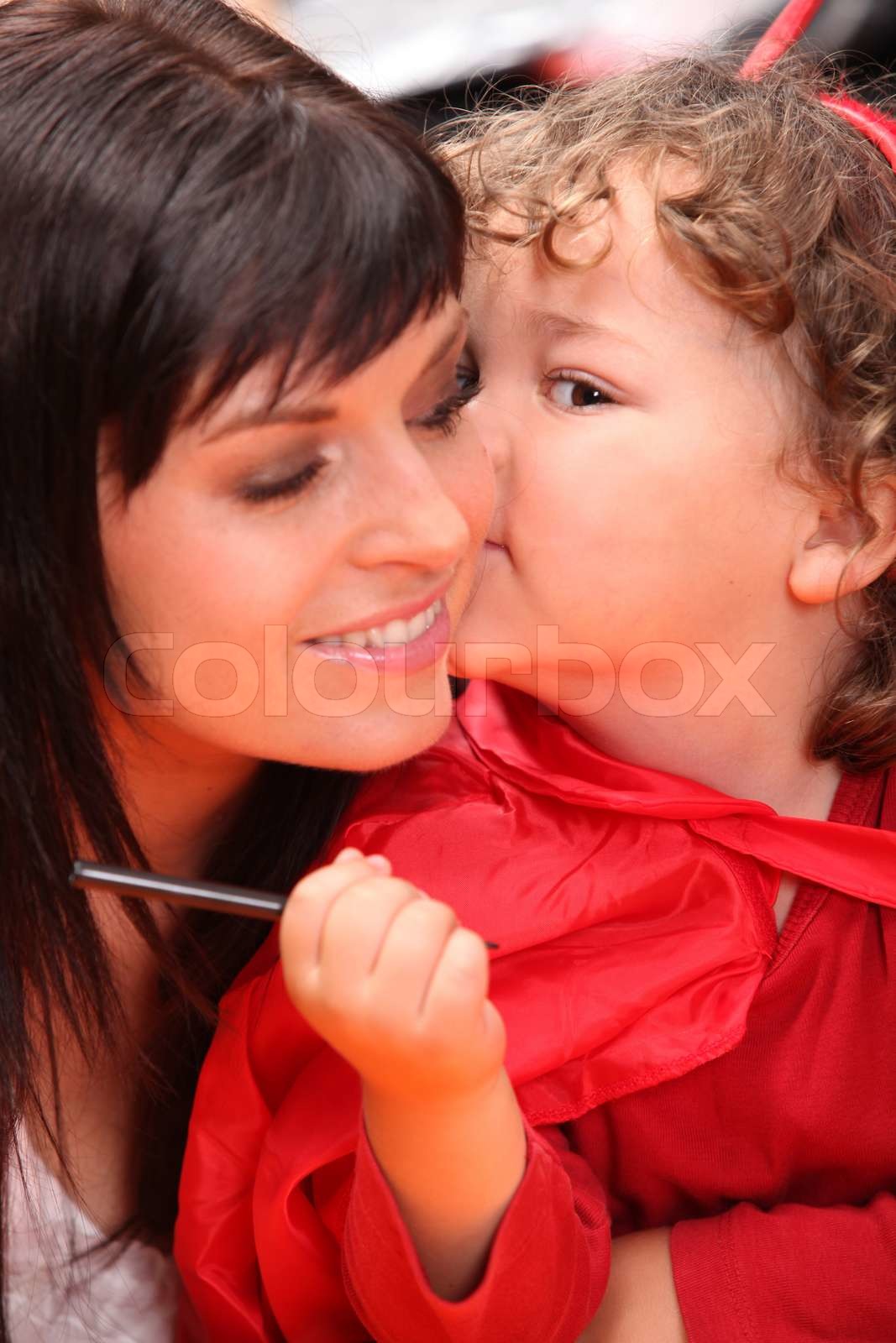 Child whispering into her mother's ear Stock image Colourbox