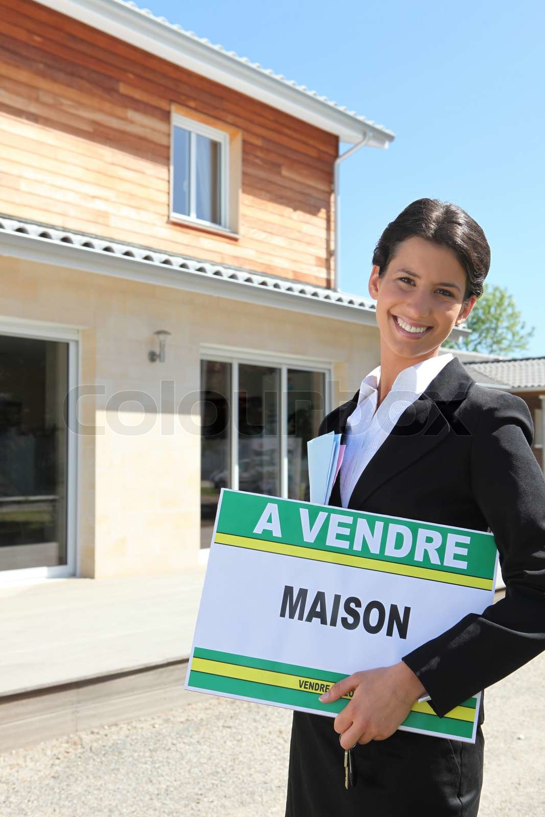 Estate agent standing in front of a house | Stock image | Colourbox