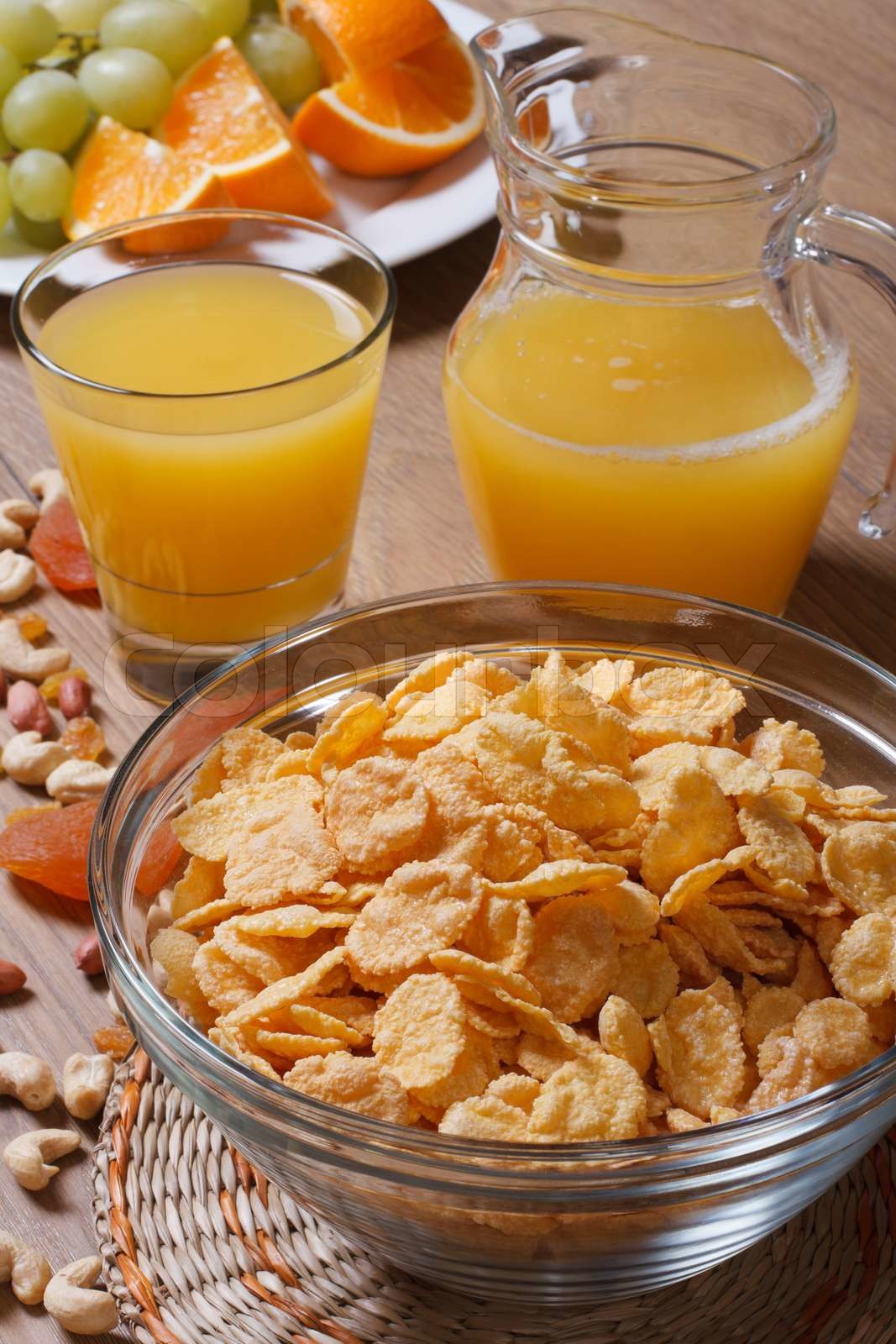 Corn Flakes mit getrockneten Früchten und Orangensaft. vertikale ...