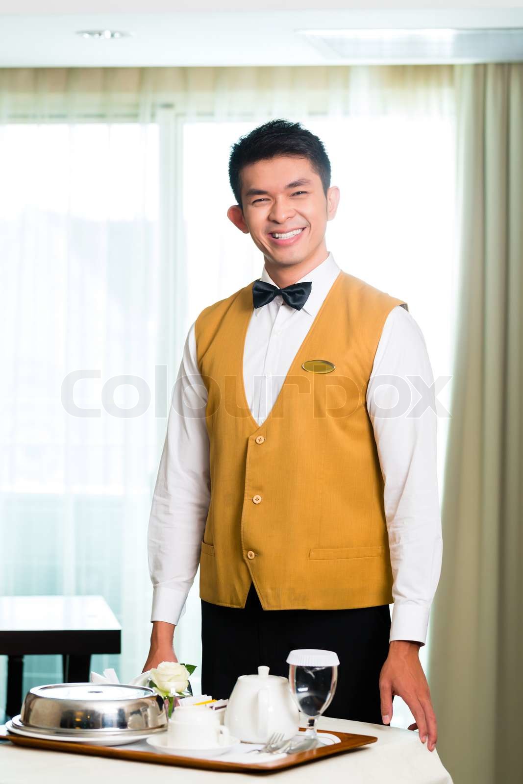 Asian Chinese room service waiter serving food in hotel | Stock image