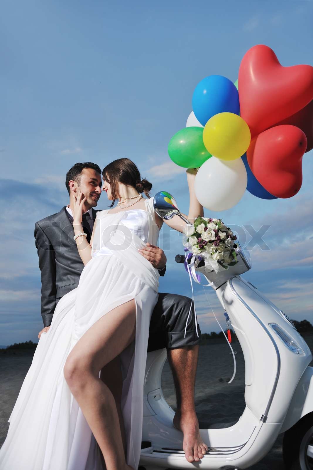 just married couple on the beach ride white scooter | Stock image