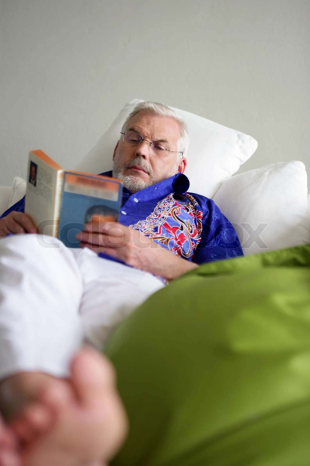 Elderly man reading in bed | Stock image | Colourbox