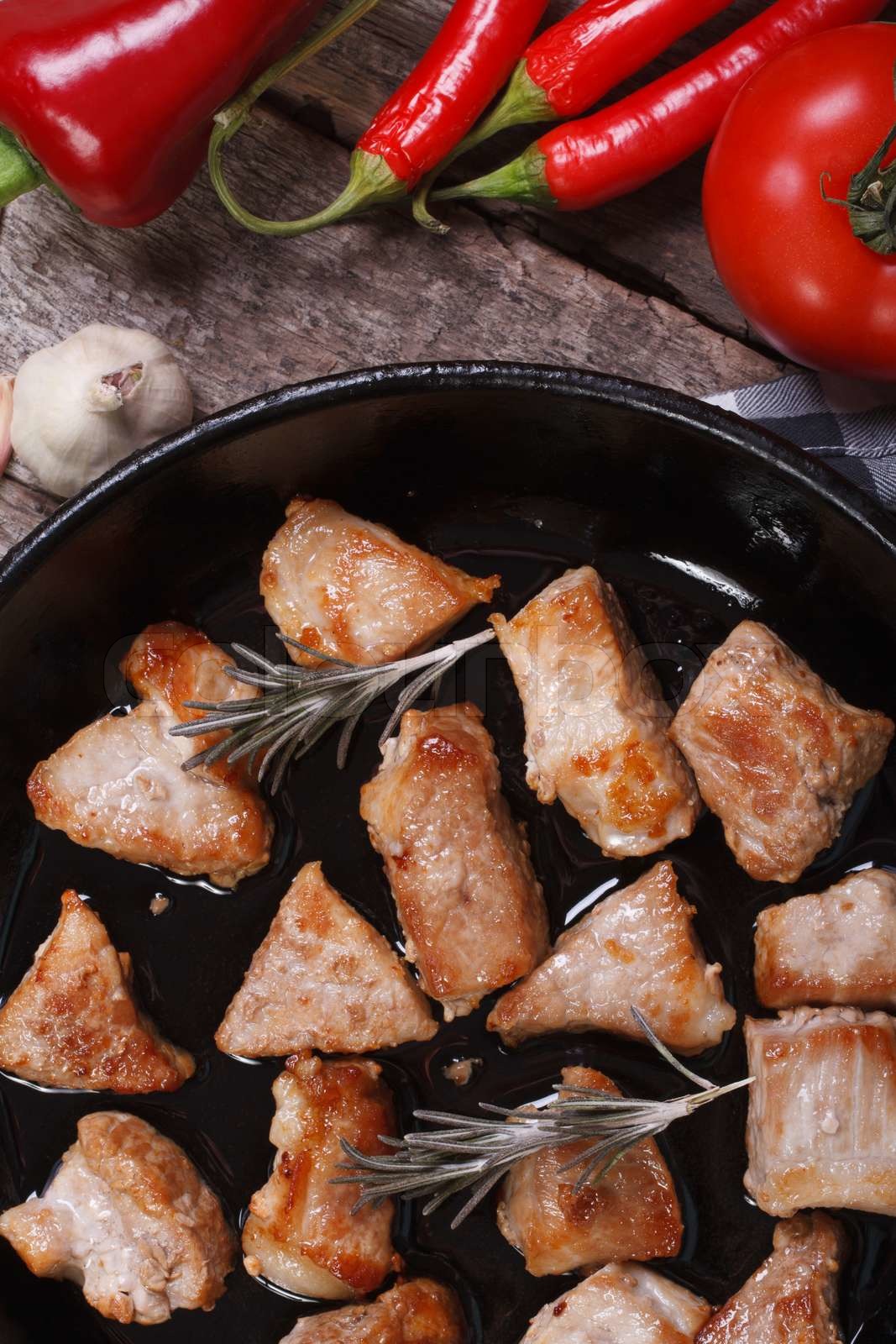 gebratenes Schweinefleisch in der Pfanne mit Rosmarin und Gemüse ...