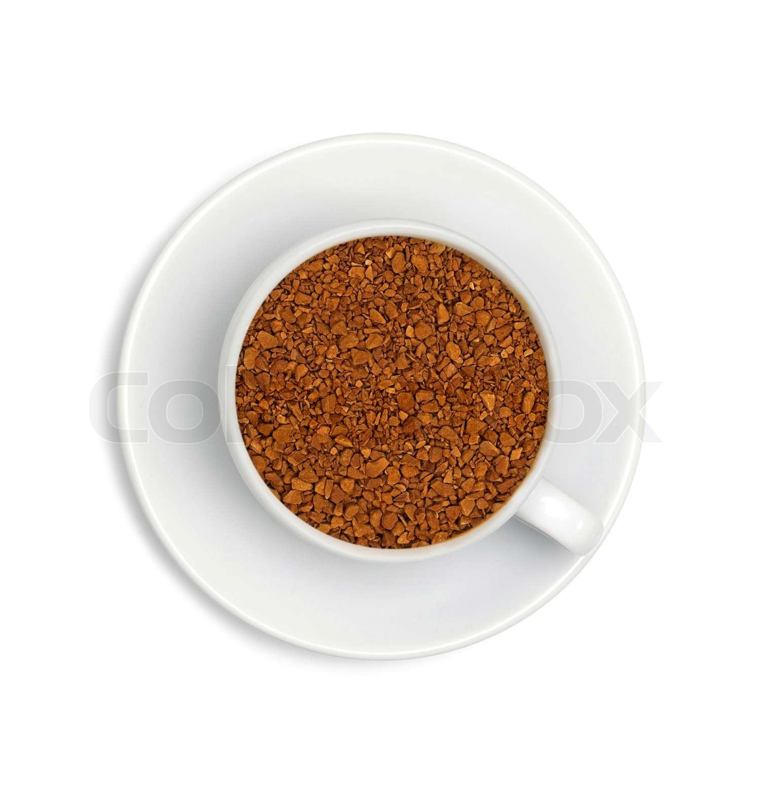 granules of instant coffee in a white cup and saucer isolated on white