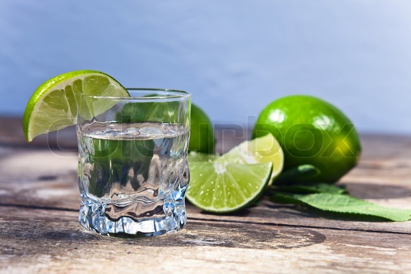 Tequila and lime on a old wooden table Stock Photo Colourbox