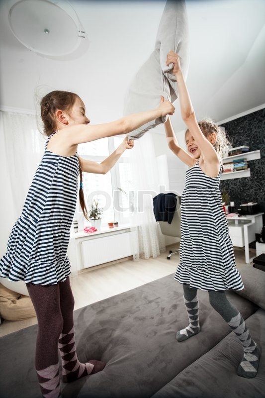 Two Little Girls Pillow Fighting In Stock Image Colourbox
