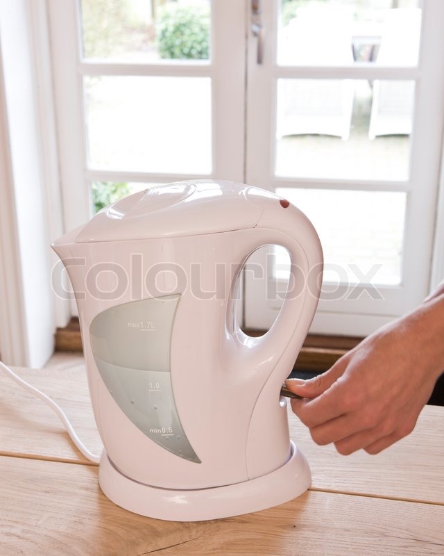 Turning the electric kettle on Stock image Colourbox